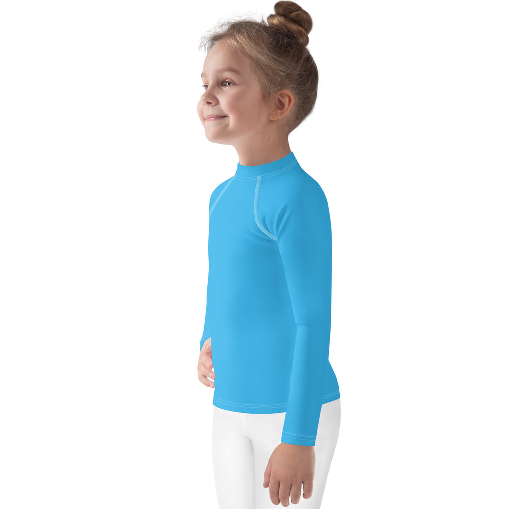 Young girl wearing a bright blue kids sky blue long sleeve rash guard swim shirt with upf 50 plus protection