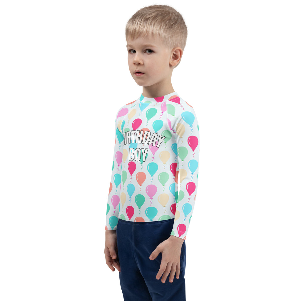 A child wearing a white long sleeve rash guard with colorful pastel balloons and birthday boy text with UPF 50+ protection