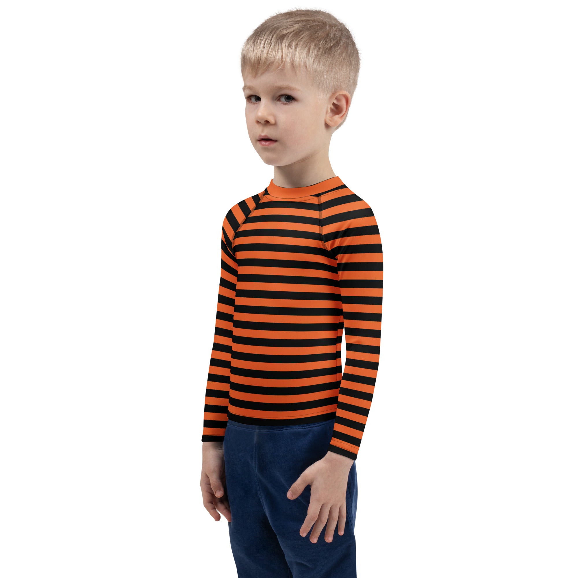 A child wearing a kids orange and black halloween long sleeve rash guard swim shirt with UPF 50+ protection
