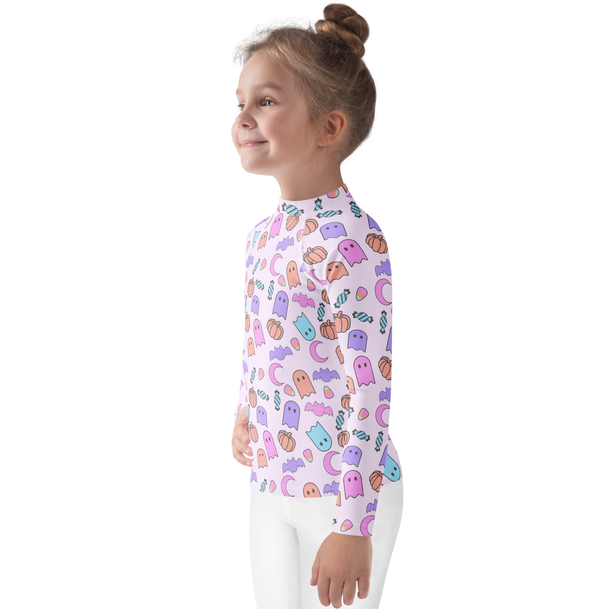 A child wearing a white girls halloween pattern long sleeve rash guard swim shirt with pastel ghosts pumpkins and bats