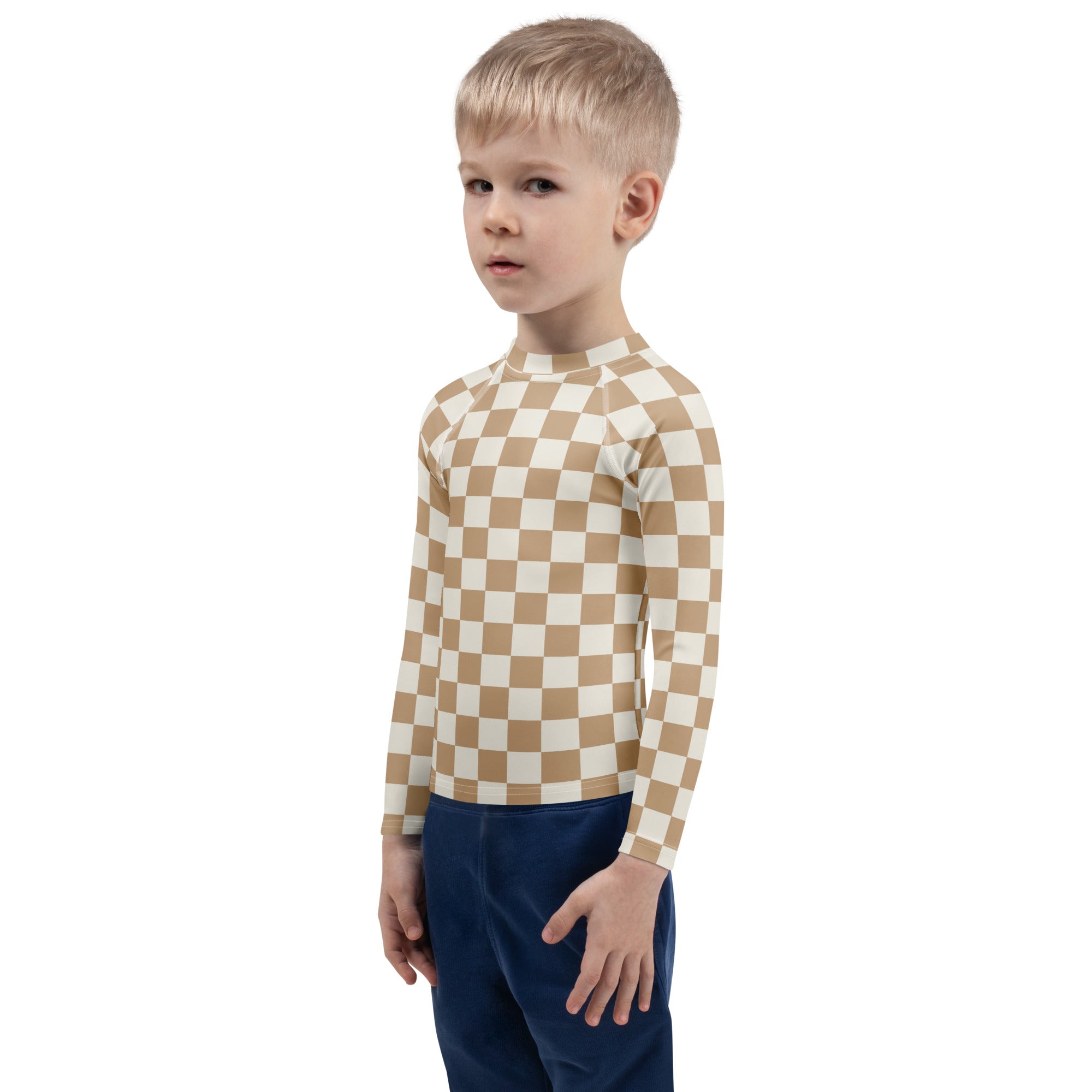 A child wearing a beige and cream checkered kids sand checkerboard long sleeve rash guard swim shirt with UPF 50+