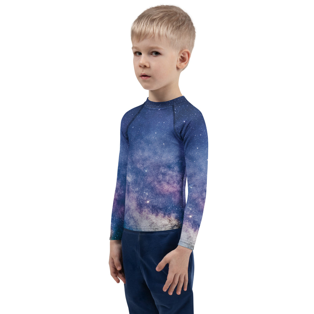 A child wearing a kids realistic galaxy long sleeve rash guard swim shirt with upf 50 plus in deep blue and purple