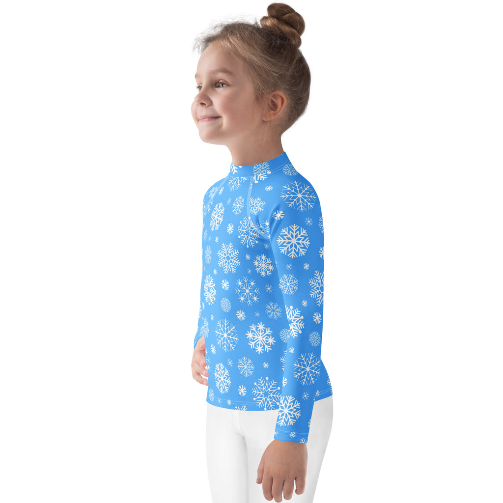 A child wearing a kids blue snowflake long sleeve rash guard swim shirt with UPF 50 plus for sun protection