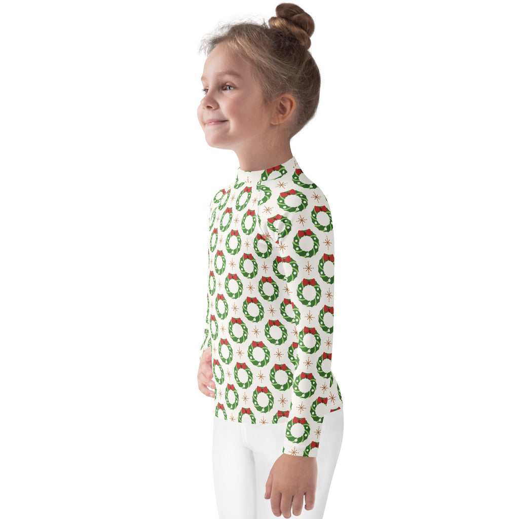 A child wearing a white kids christmas wreath long sleeve rash guard swim shirt with UPF 50 plus protection