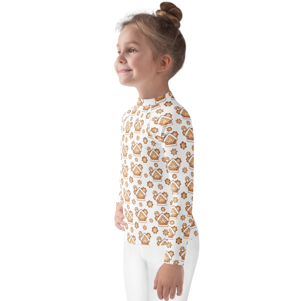 A child wearing a white kids gingerbread house Christmas long sleeve rash guard swim shirt with UPF 50+
