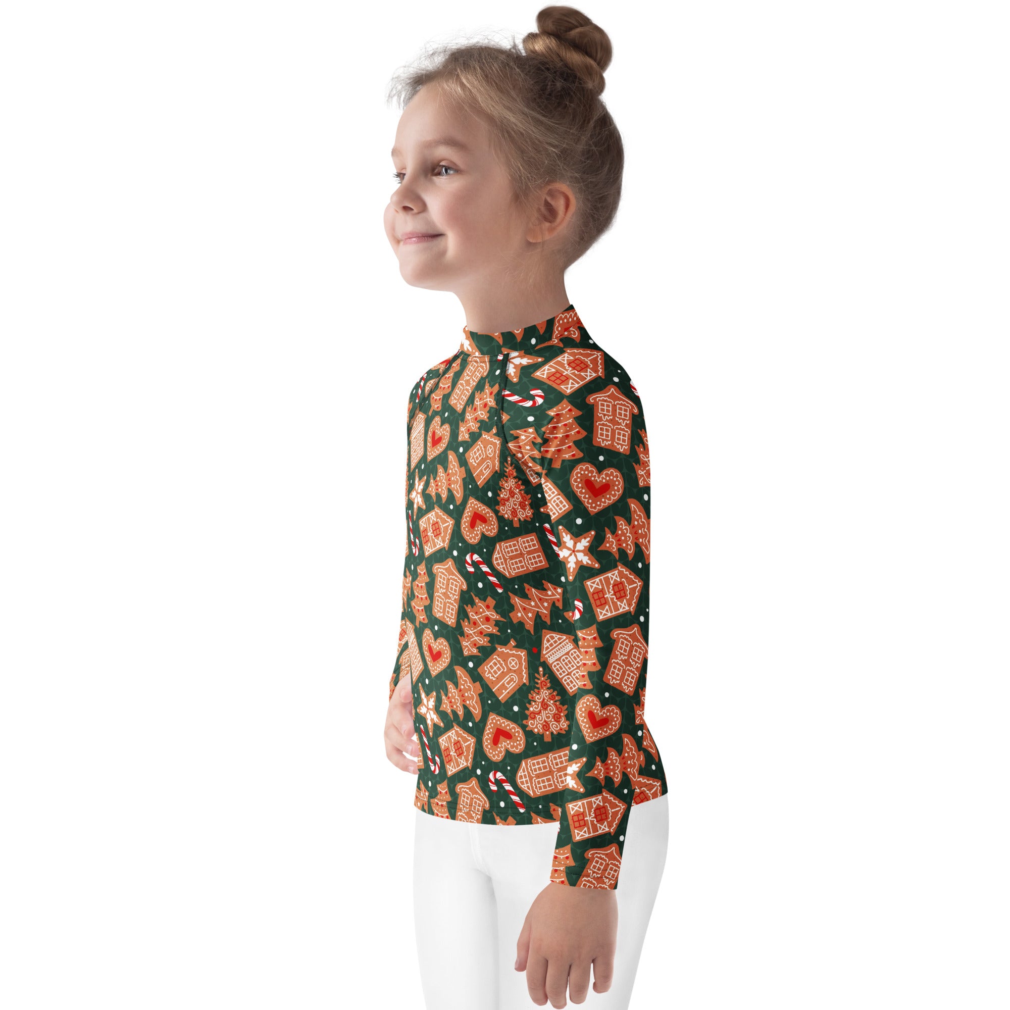 A child wearing a kids green gingerbread christmas long sleeve rash guard swim shirt with upf 50 plus and festive pattern