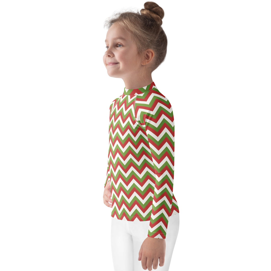 A child wearing a kids red and green chevron Christmas long sleeve rash guard swim shirt with UPF 50+ protection