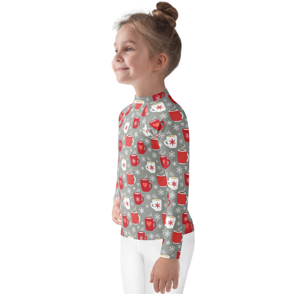 A child wearing a gray kids hot cocoa christmas long sleeve rash guard swim shirt with red and white mugs and UPF 50+