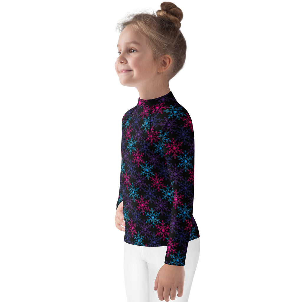 A kids neon snowflakes long sleeve rash guard swim shirt with upf 50 plus featuring glowing pink and blue snowflakes on black fabric