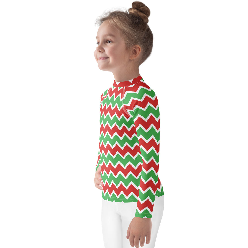 A child wearing a kids christmas chevron long sleeve rash guard swim shirt with upf 50 plus in red green and white