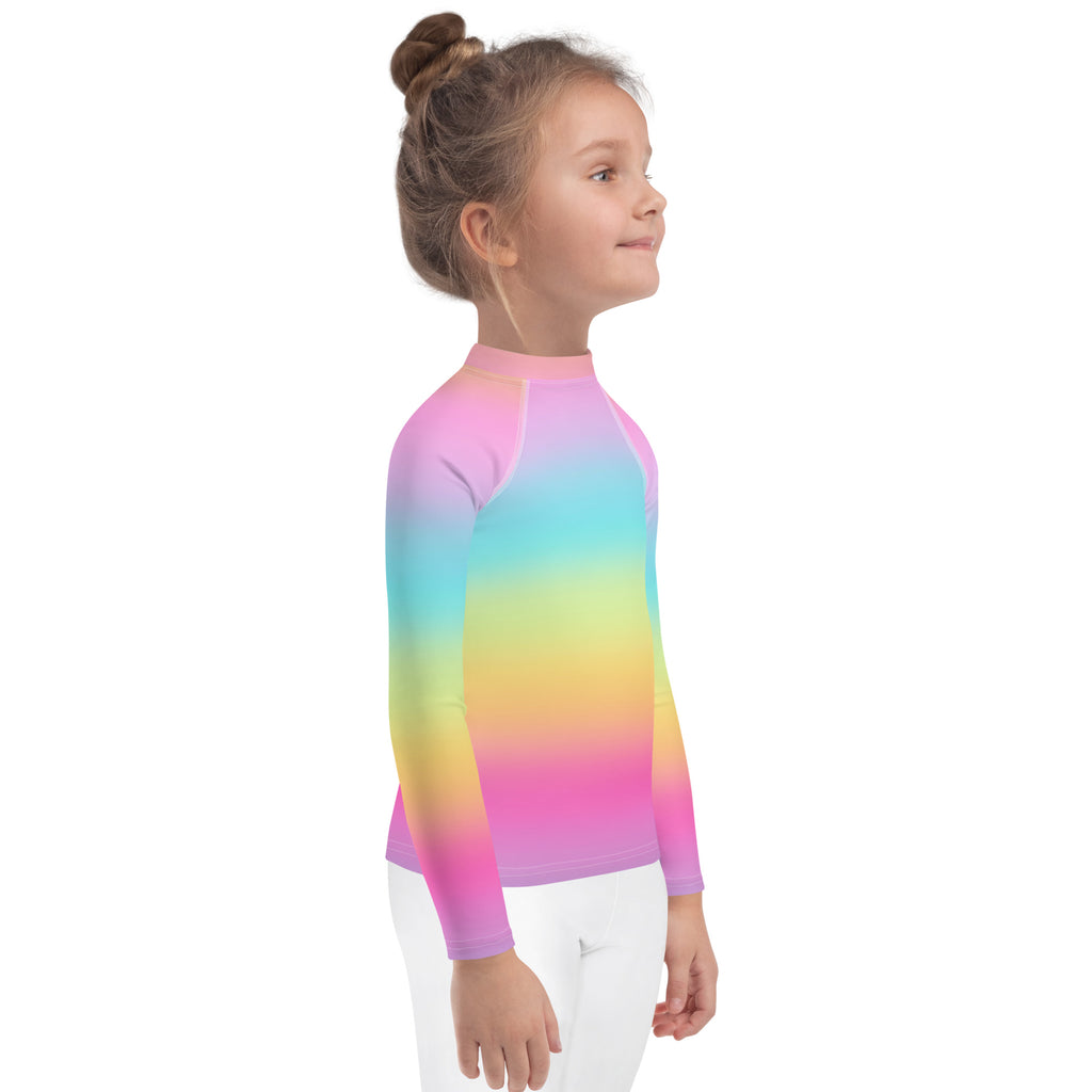 A child wearing a girls bright rainbow long sleeve rash guard with smooth stretchy fabric and UPF 50 plus protection