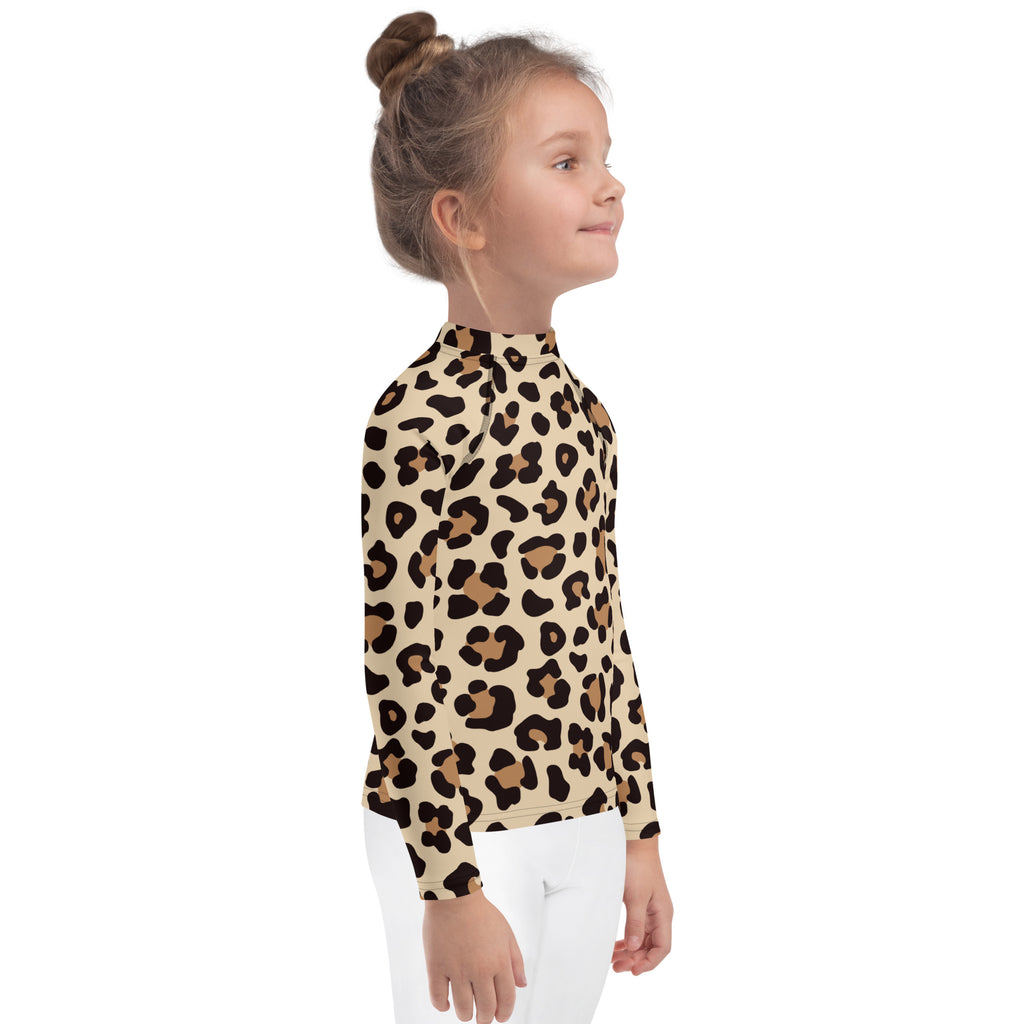 A child wearing a beige kids leopard print long sleeve rash guard swim shirt with UPF 50+ for sun protection