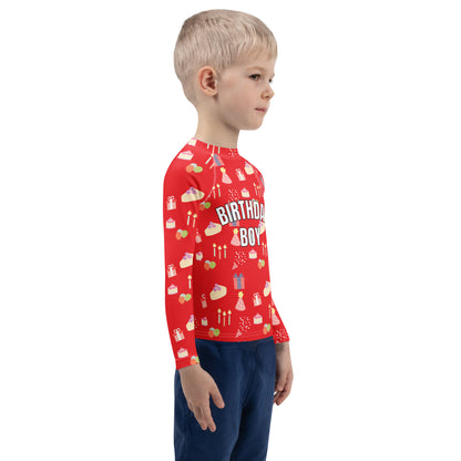 Child wearing a red 'Birthday Boy' shirt with birthday patterns on a white background