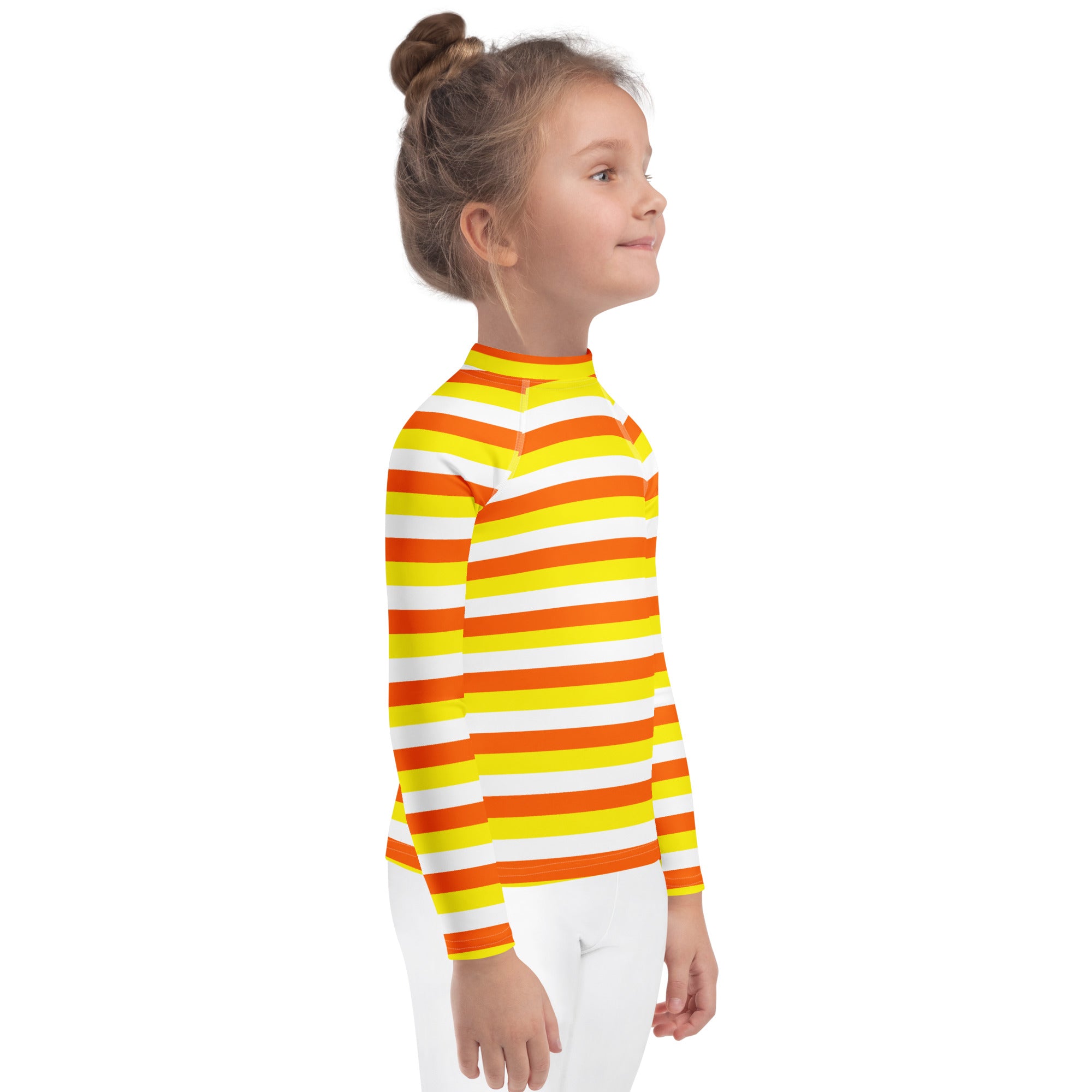 A child wearing a kids candy corn stripes halloween long sleeve rash guard swim shirt with upf 50 plus in orange and yellow