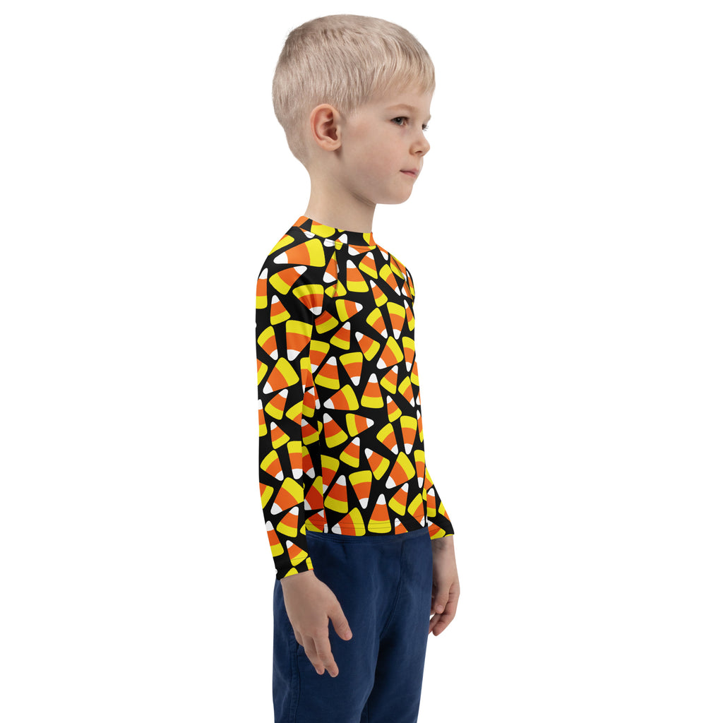A kids candy corn halloween long sleeve rash guard swim shirt with upf 50 plus featuring orange yellow and white candy corn on black