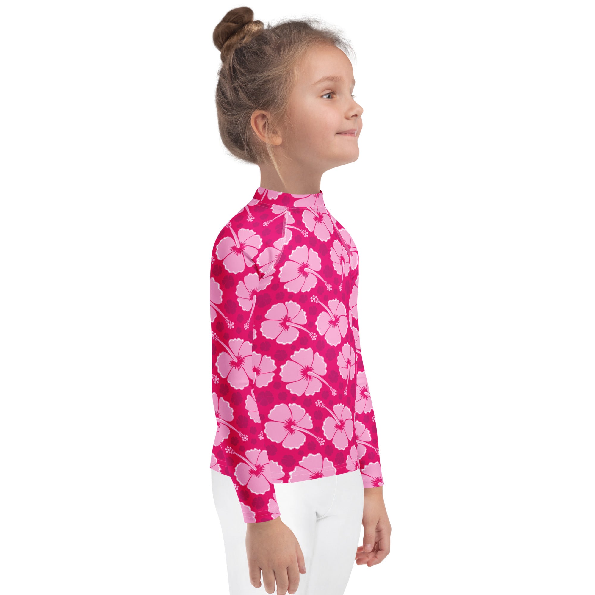 A vibrant pink girls long sleeve rash guard with light pink hibiscus pattern and UPF 50 plus for tropical swim protection