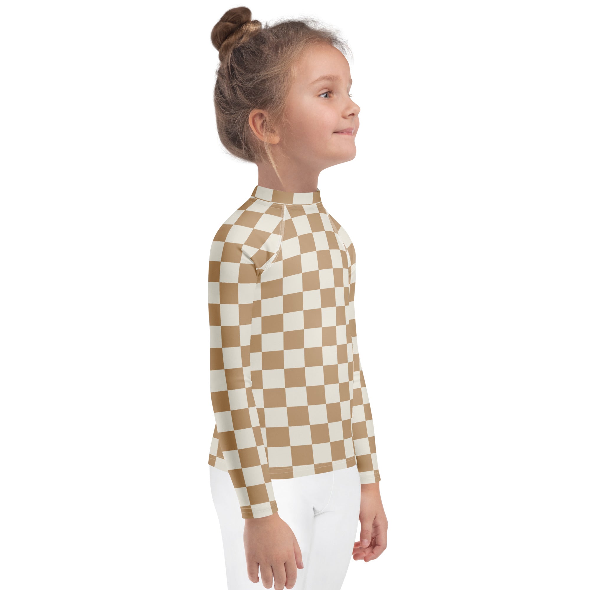 A child wearing a tan and cream checkered kids sand checkerboard long sleeve rash guard with UPF 50+ protection