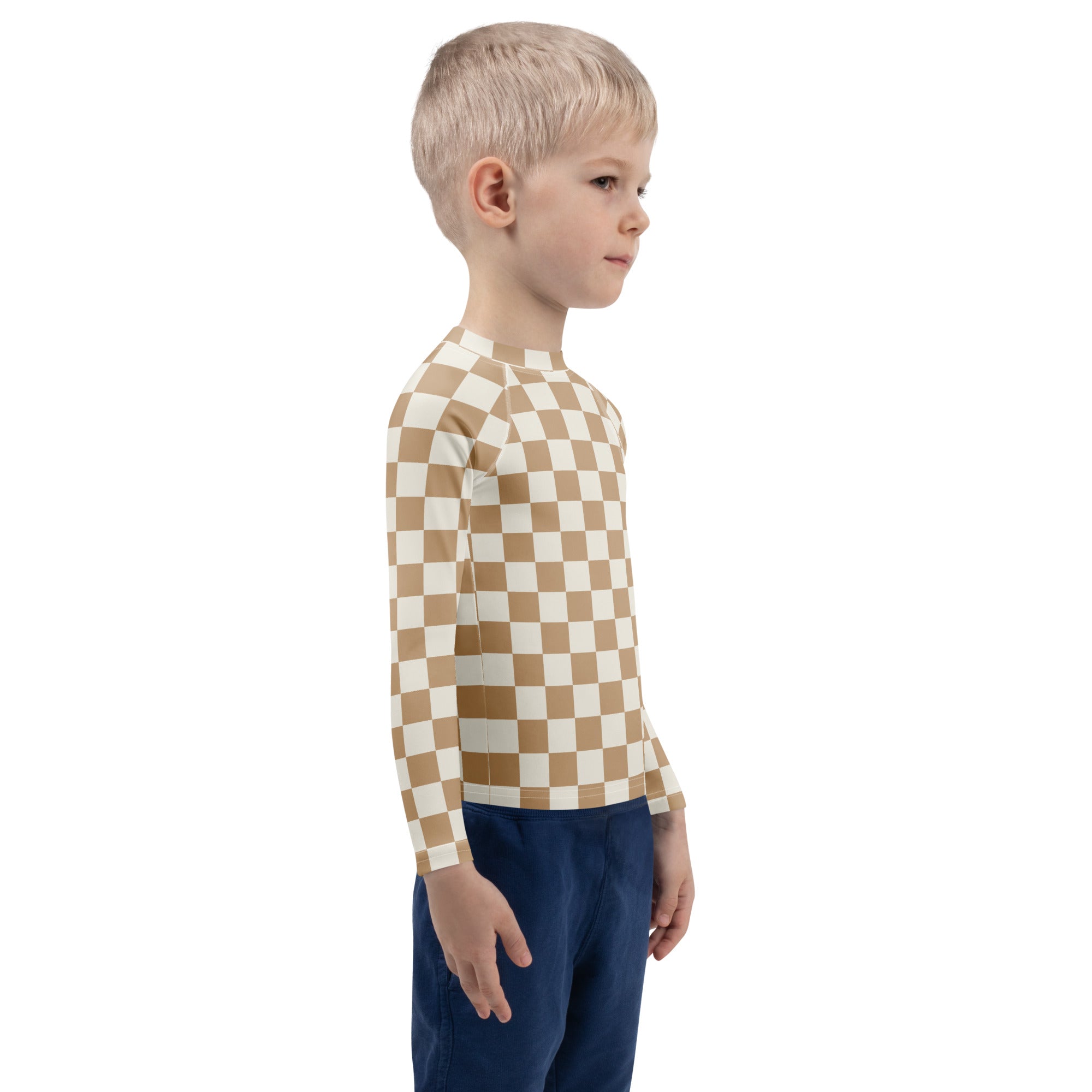 A child wearing a tan and cream checkerboard kids sand long sleeve rash guard swim shirt with UPF 50+ protection