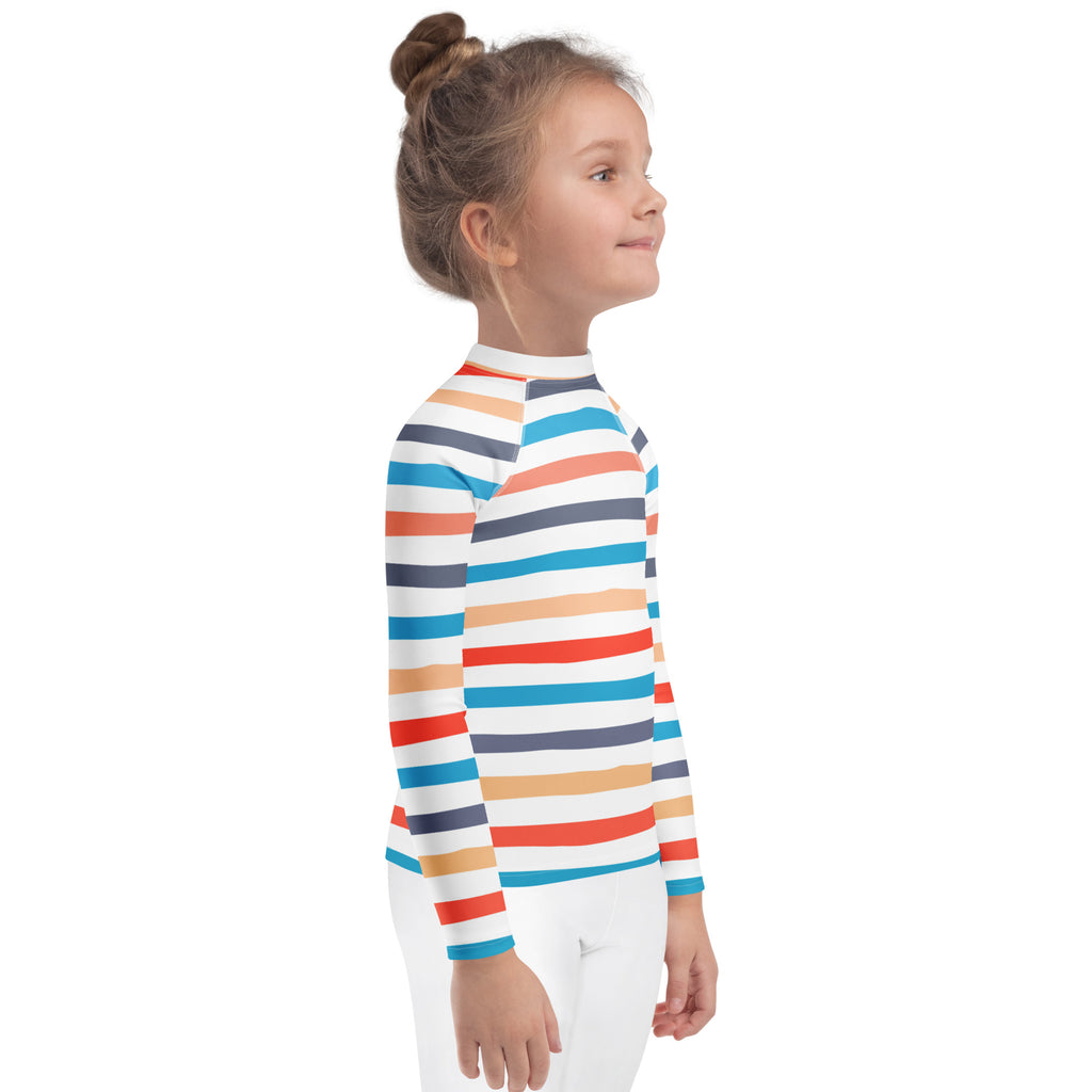 A child wearing a kids coastal stripes long sleeve rash guard swim shirt with upf 50 plus in orange blue teal and navy