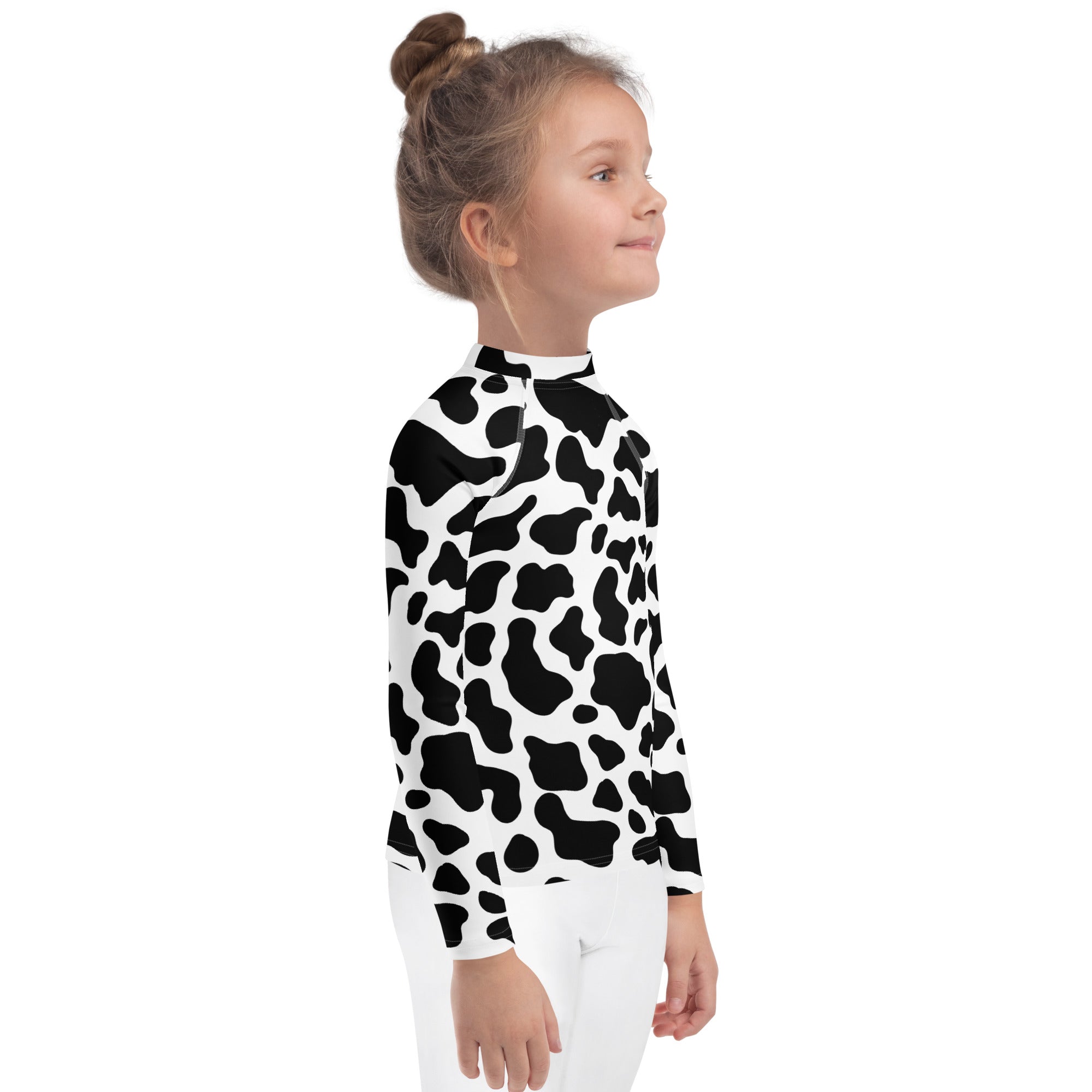 A child wearing a black and white cow print long sleeve rash guard swim shirt with UPF 50+ for sun protection