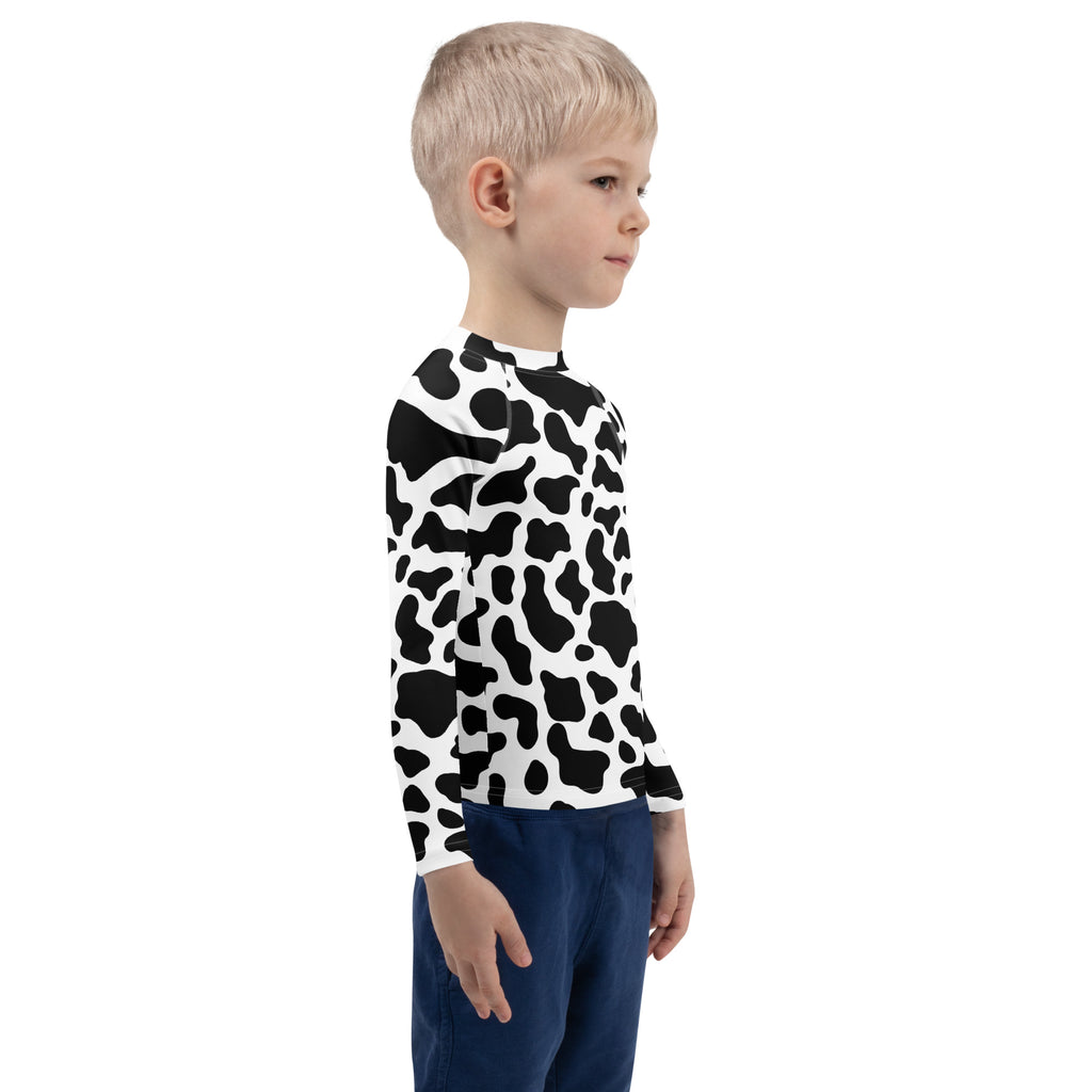 A child wearing a black and white cow print long sleeve rash guard swim shirt with UPF 50 plus protection