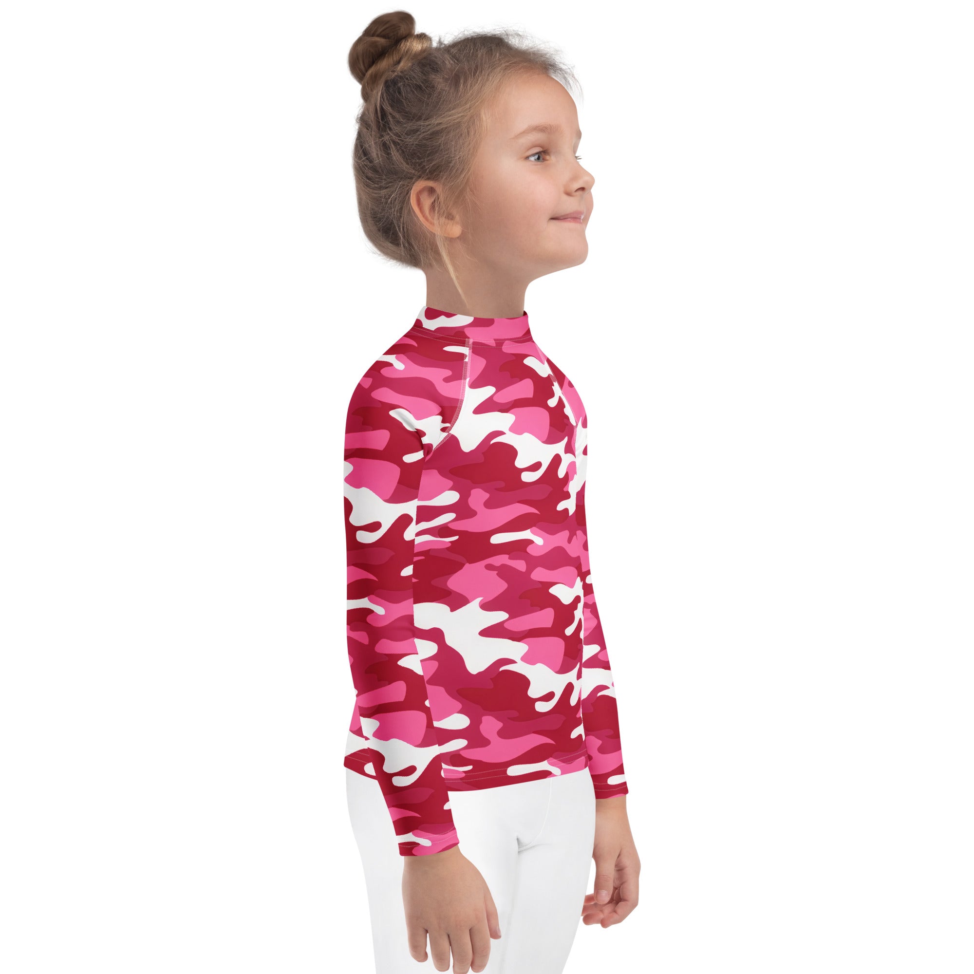 A girl wearing a girls pink camouflage long sleeve rash guard swim shirt with UPF 50 plus protection