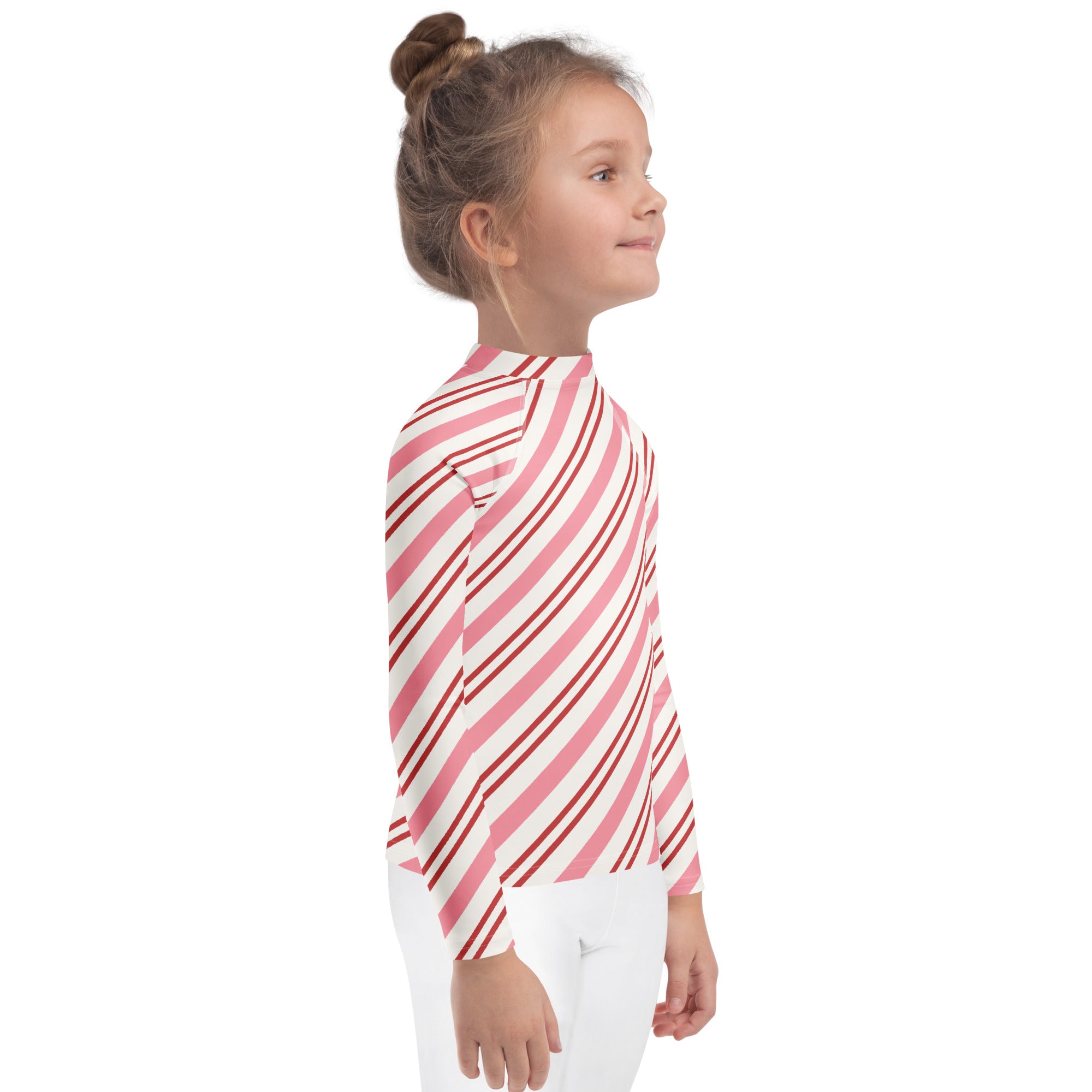 A child wearing a kids pink peppermint stripe Christmas long sleeve rash guard swim shirt with UPF 50+
