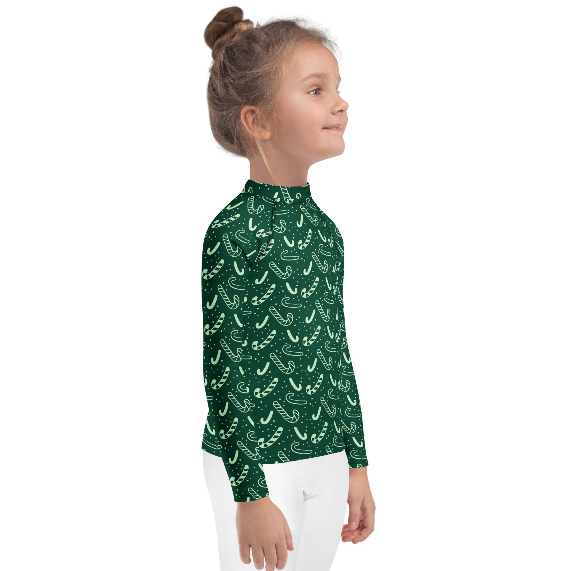 A child wearing a kids green candy cane Christmas long sleeve rash guard swim shirt with UPF 50 plus protection
