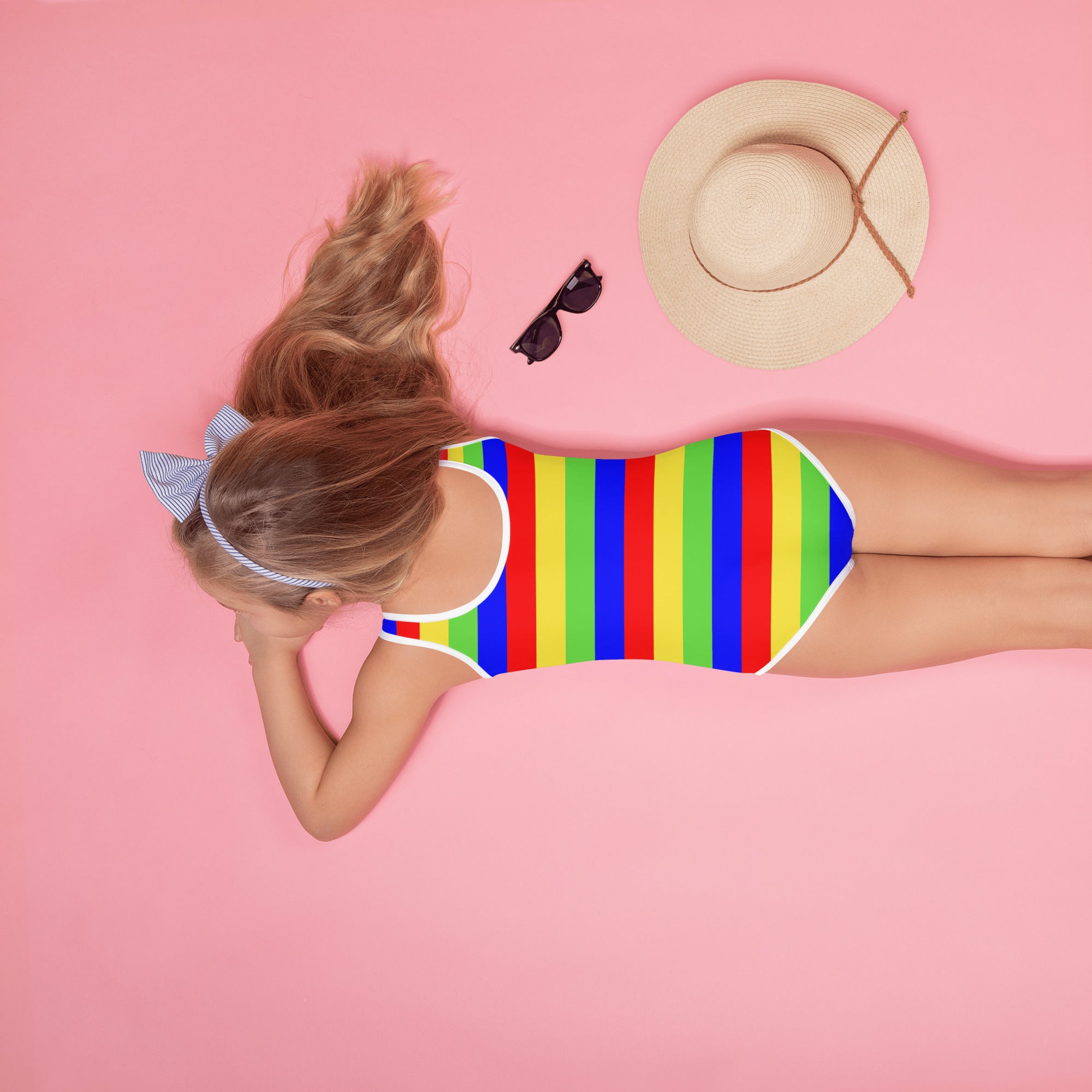 A vibrant rainbow-striped girls bright stripes buttery soft swimsuit with white trim and upf 50 plus protection