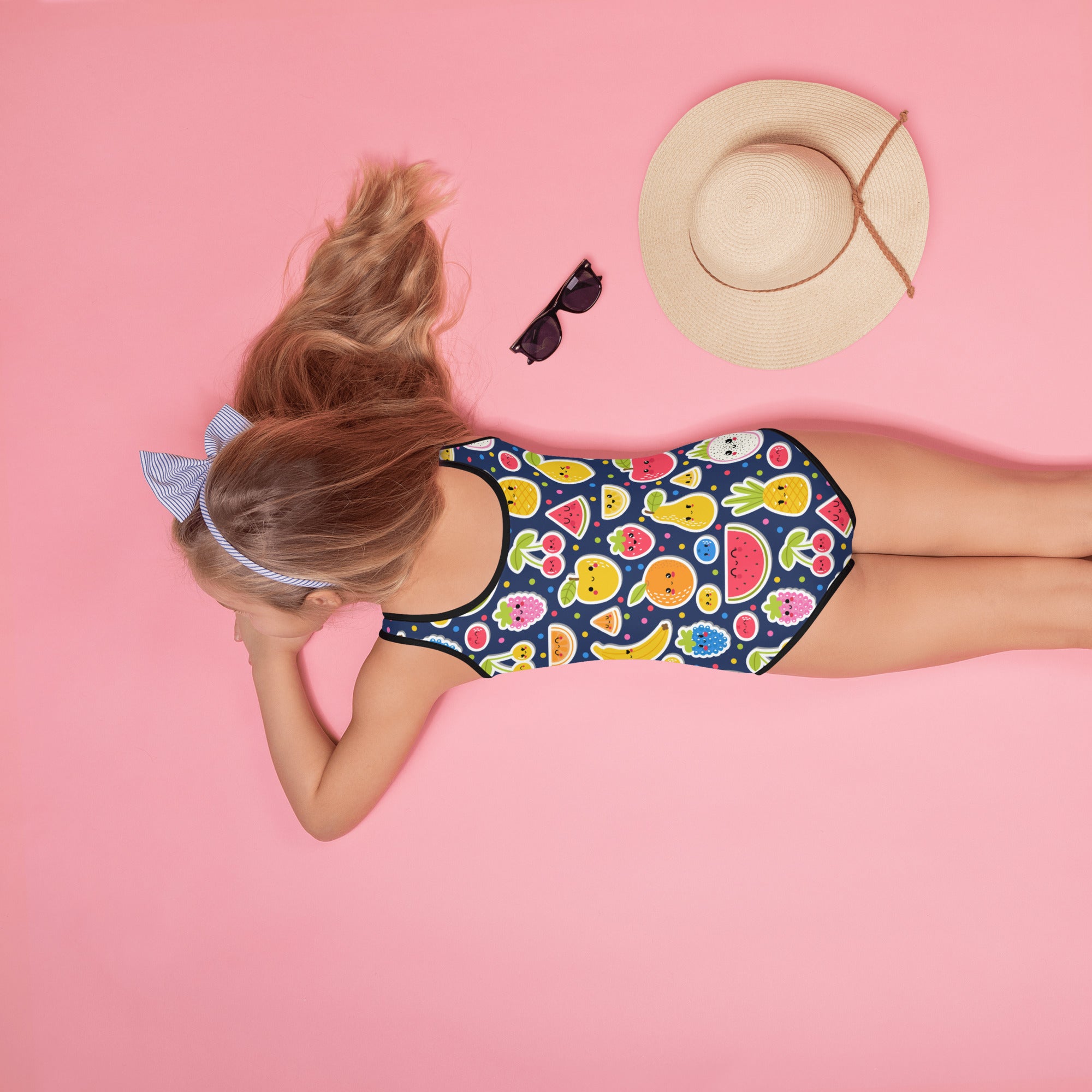 A navy blue girls emoji fruit buttery soft one-piece swimsuit with colorful fruit pattern and UPF 50 plus protection