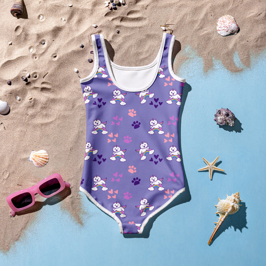 Girls purple one-piece swimsuit with white trim featuring playful cartoon unicorns rainbows paw prints and hearts with upf 50+