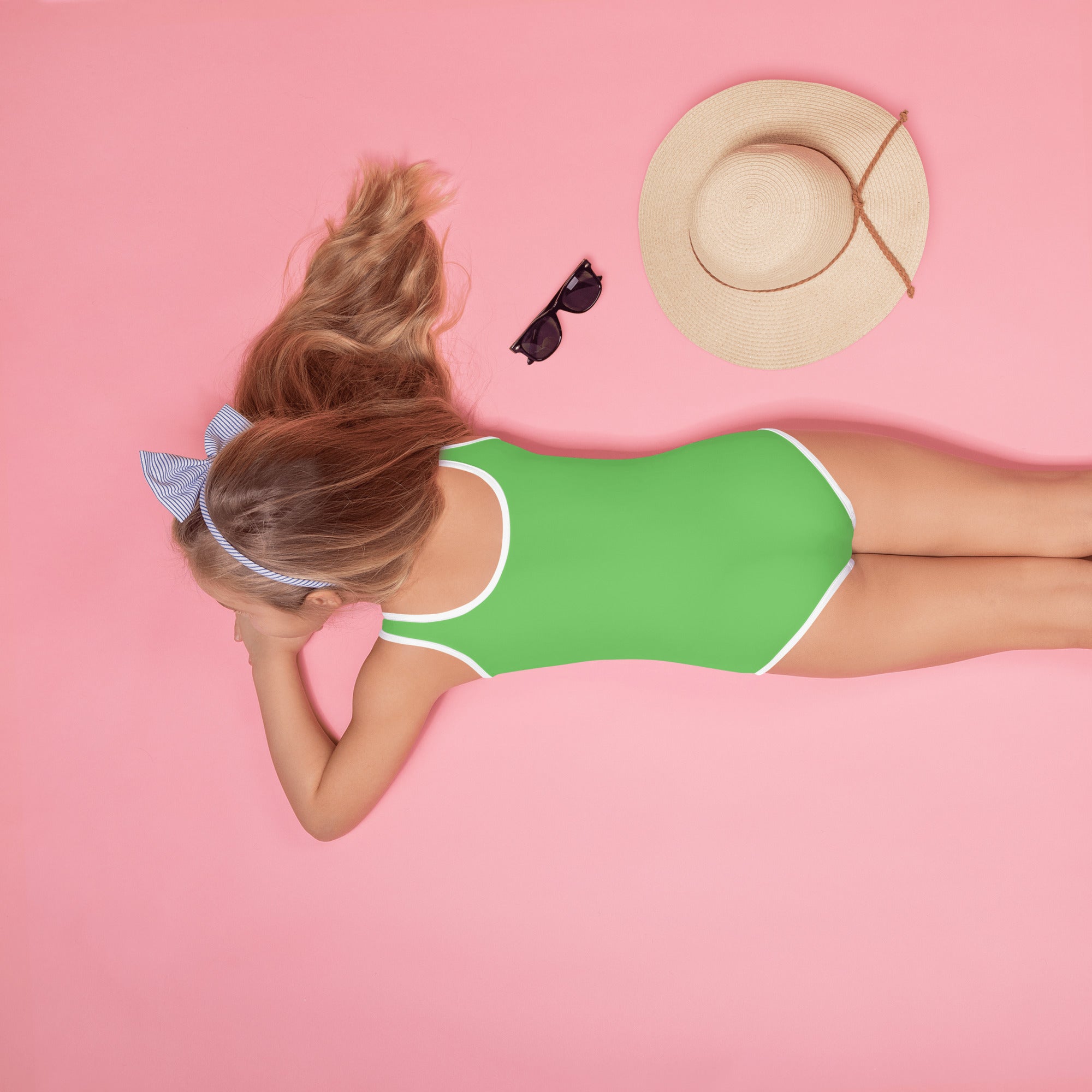 A vibrant green buttery soft one-piece swimsuit for girls with white trim and UPF 50 plus sun protection