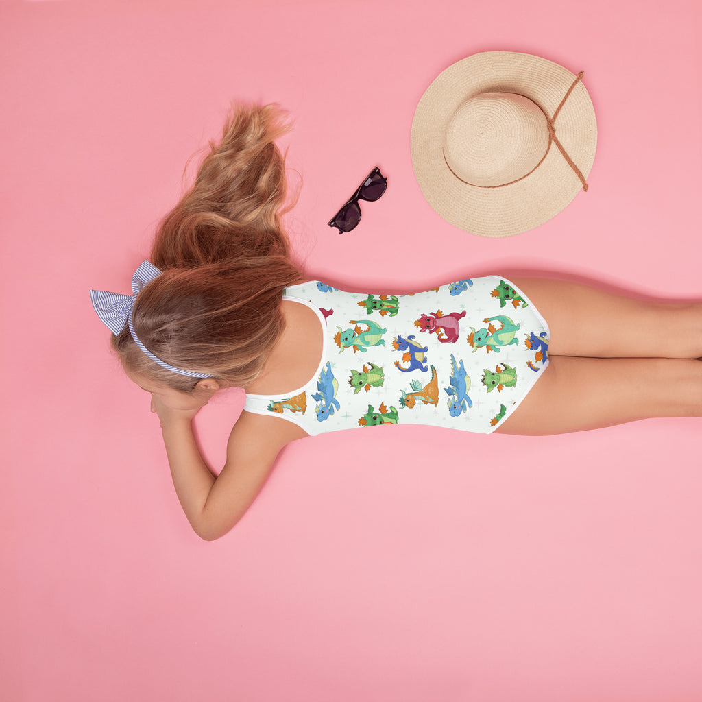 White girls one-piece swimsuit with colorful cartoon dinosaurs in green blue and pink buttery soft fabric with UPF 50+