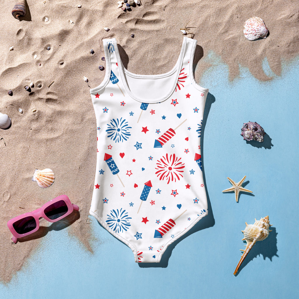 Girls buttery soft white one-piece swimsuit with red blue star fireworks pattern for 4th of July celebration