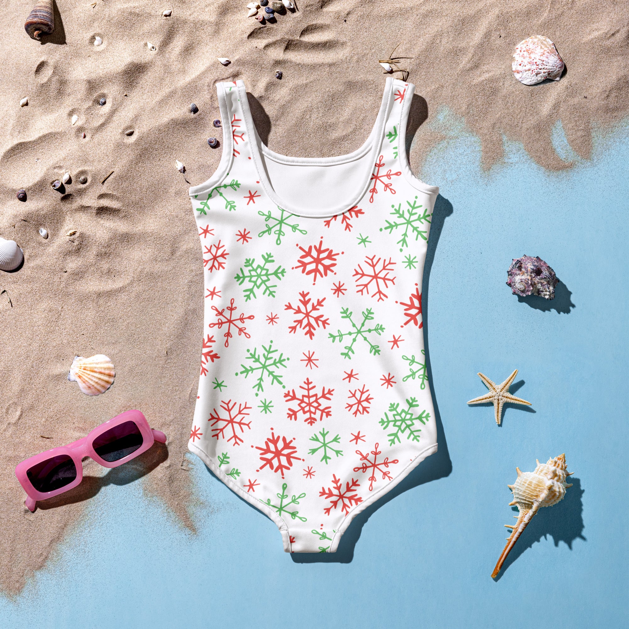 A white girls one-piece swimsuit with red and green snowflakes festive pattern for Christmas wear