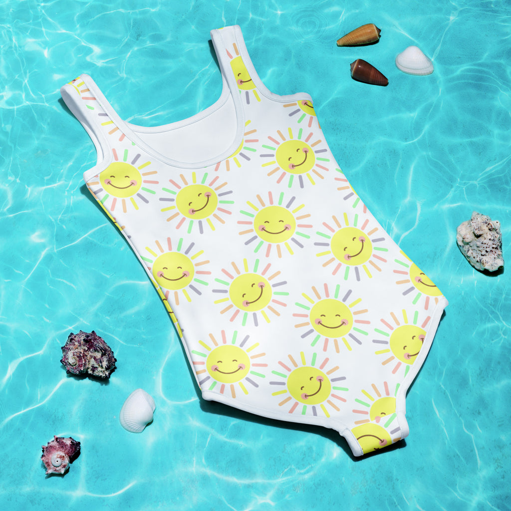 Girls colorful smile face sun buttery soft white swimsuit with yellow suns and UPF 50 plus sun protection