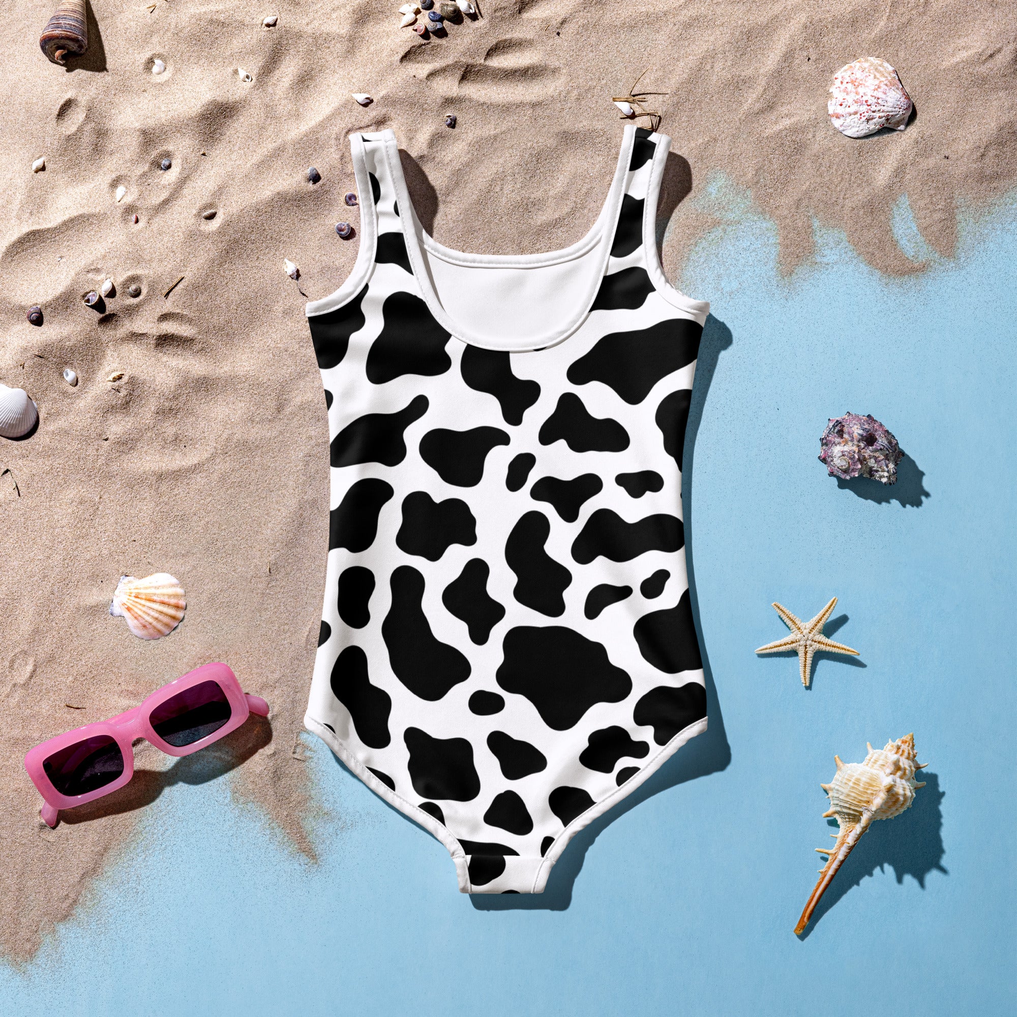 Girls cow buttery soft one-piece swimsuit in black and white cow print with scoop neckline and white trim, UPF 50+ protection