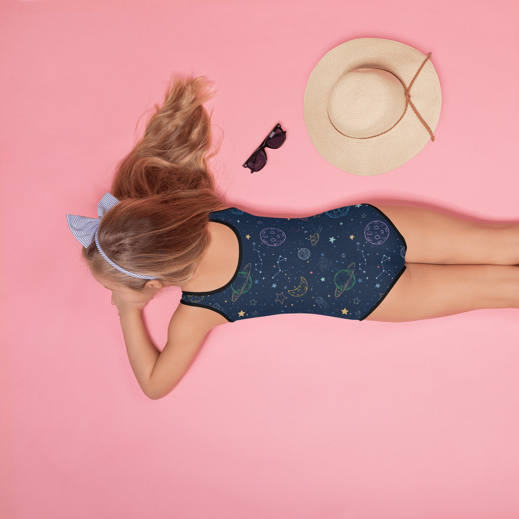 A navy blue girls one-piece swimsuit with buttery soft fabric and celestial planets stars and moons pattern with UPF 50+
