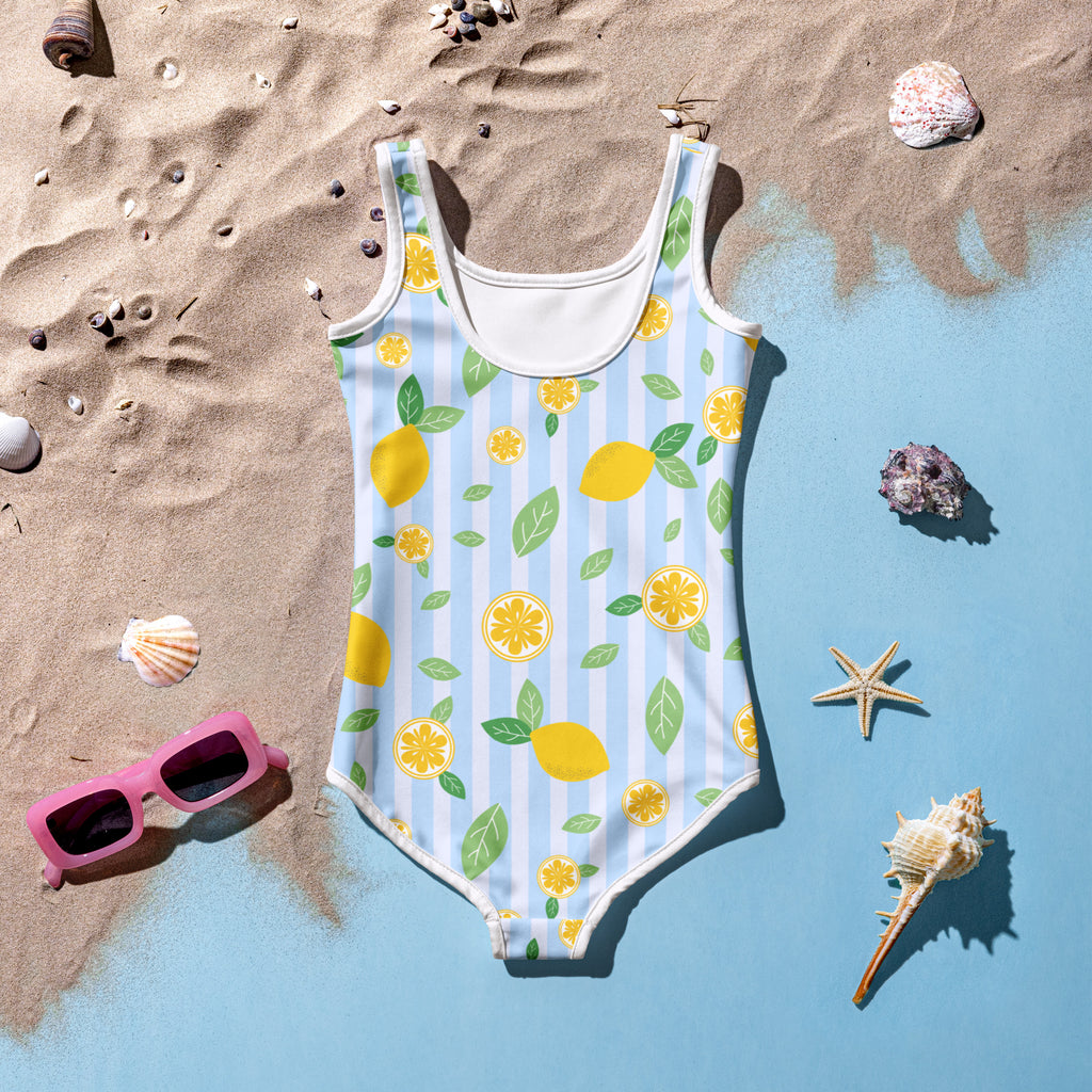 A girls light blue one-piece swimsuit with white trim and lemon slice pattern with upf 50 plus buttery soft fabric