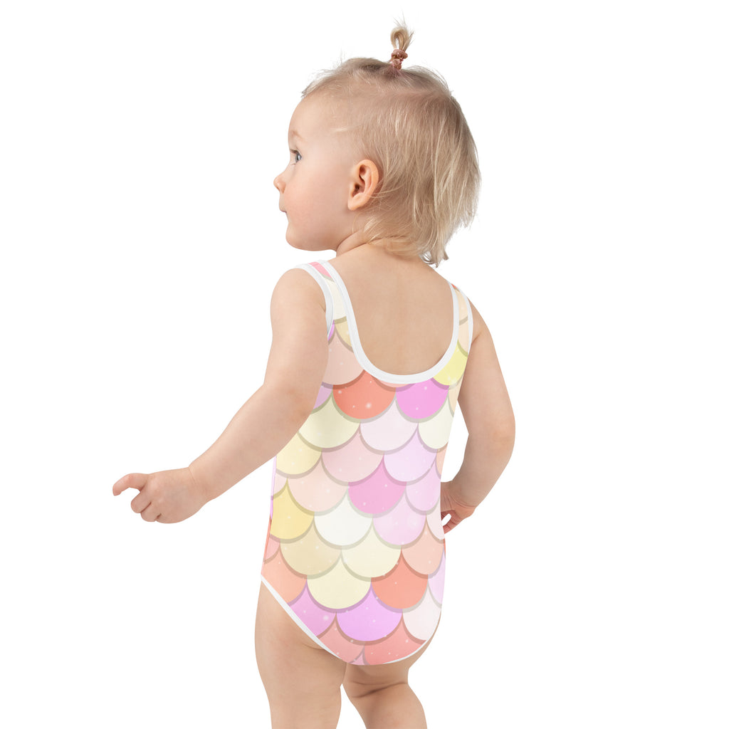 A child wearing a girls pink and orange buttery soft mermaid swimsuit with pastel scales and UPF 50 plus protection