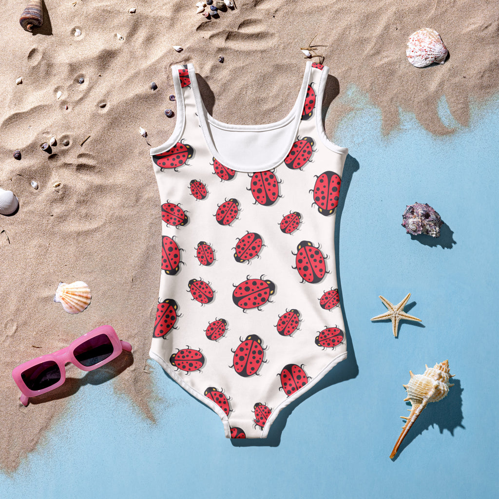 A white girls one-piece swimsuit with red ladybugs, buttery soft fabric, and UPF 50 plus sun protection