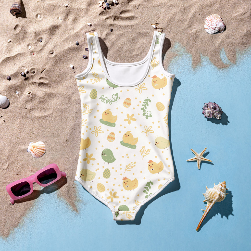 A white girls one-piece swimsuit with yellow and green cartoon chicks eggs and flowers and UPF 50 plus protection