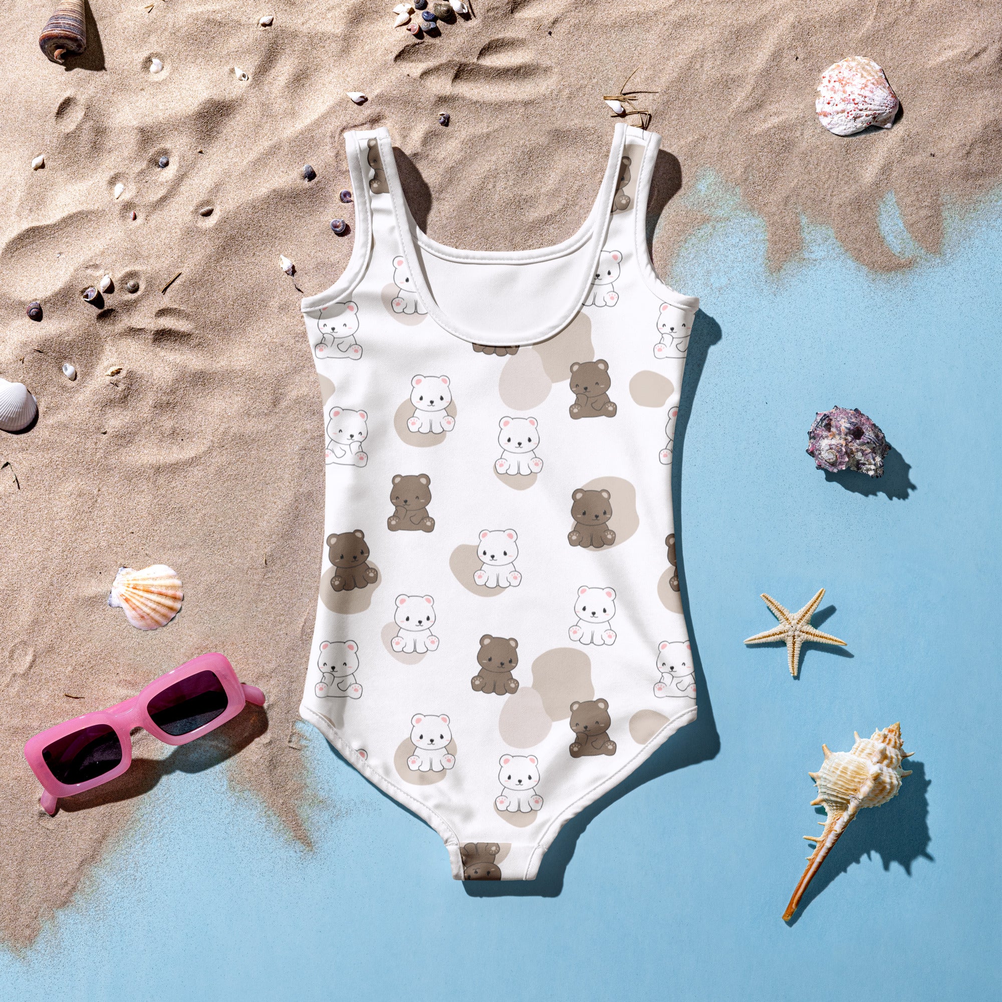 Girls cute teddy bears buttery soft white one-piece swimsuit with brown bear pattern and upf 50 plus on sandy beach decor