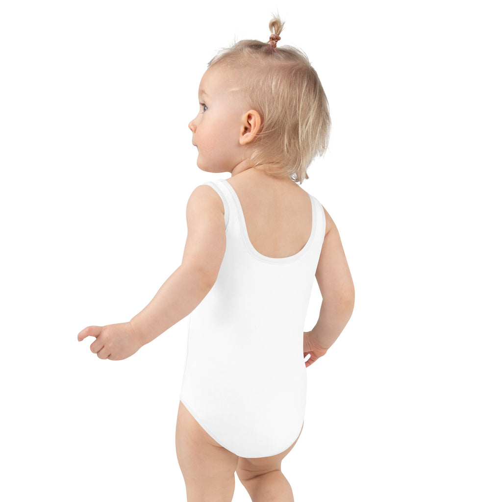 Toddler wearing a white birthday swimsuit on a white background
