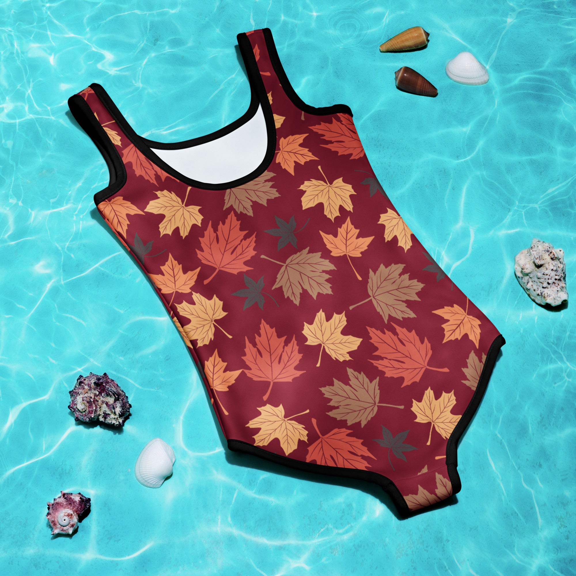 One-piece swimsuit with autumn leaf pattern on a blue water background