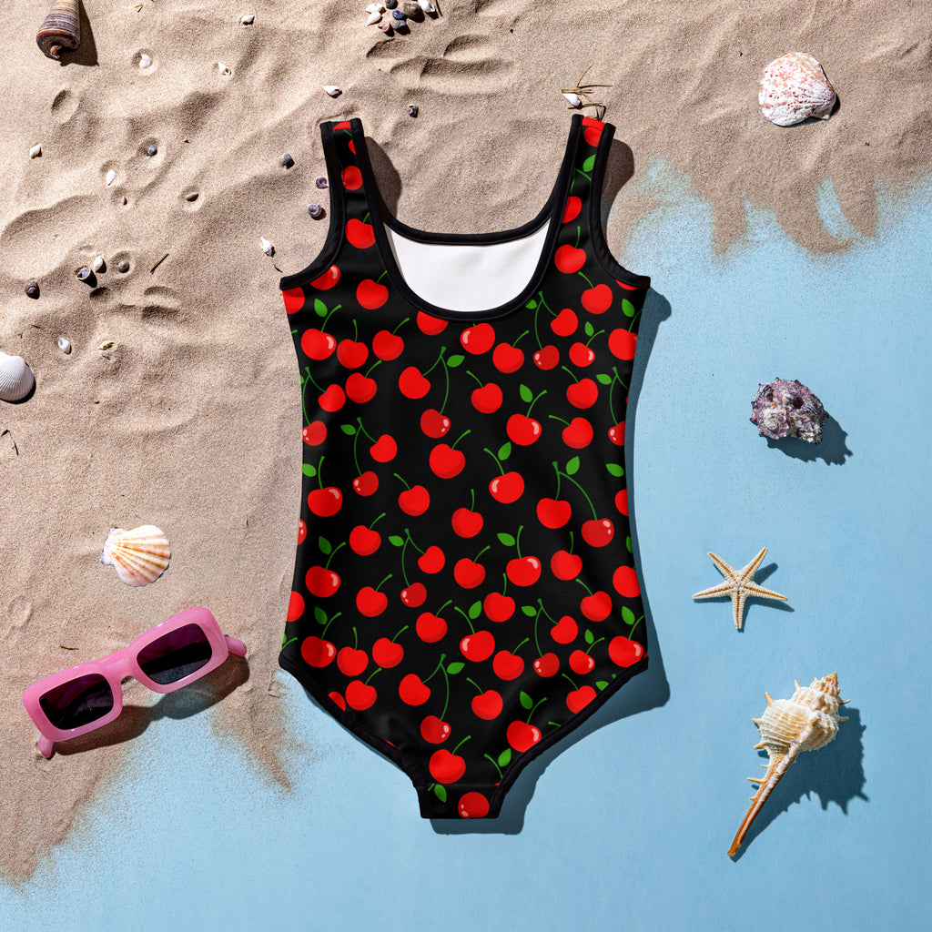 Girls red cherry buttery soft swimsuit in black with vibrant red cherry pattern green stems and white inner lining