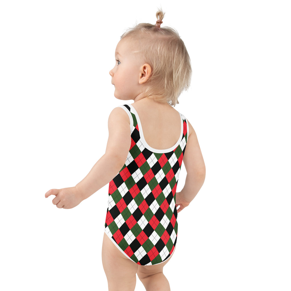 A toddler wearing a girls Christmas argyle buttery soft swimsuit in red green and black with white trim and UPF 50+ protection