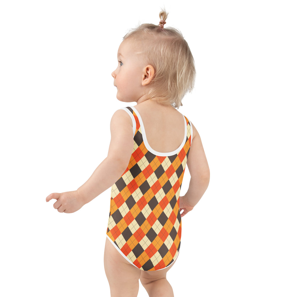 A toddler wearing a girls fall argyle buttery soft swimsuit with upf 50 plus in orange black and cream colors