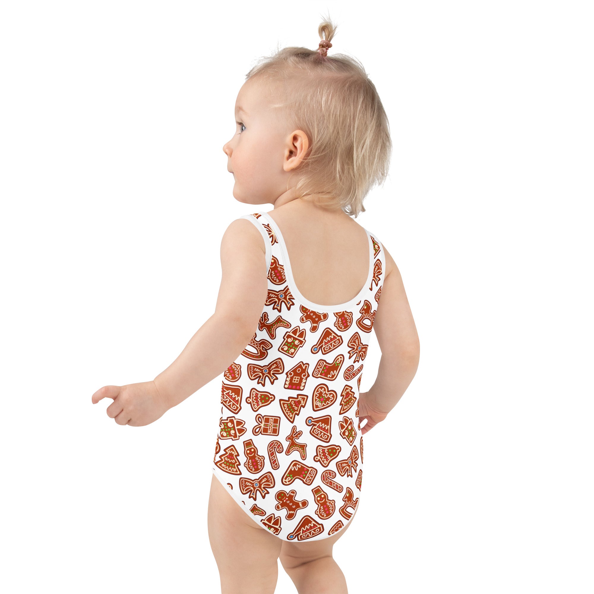 White one-piece girls swimsuit with UPF 50 plus featuring a festive orange gingerbread cookie pattern