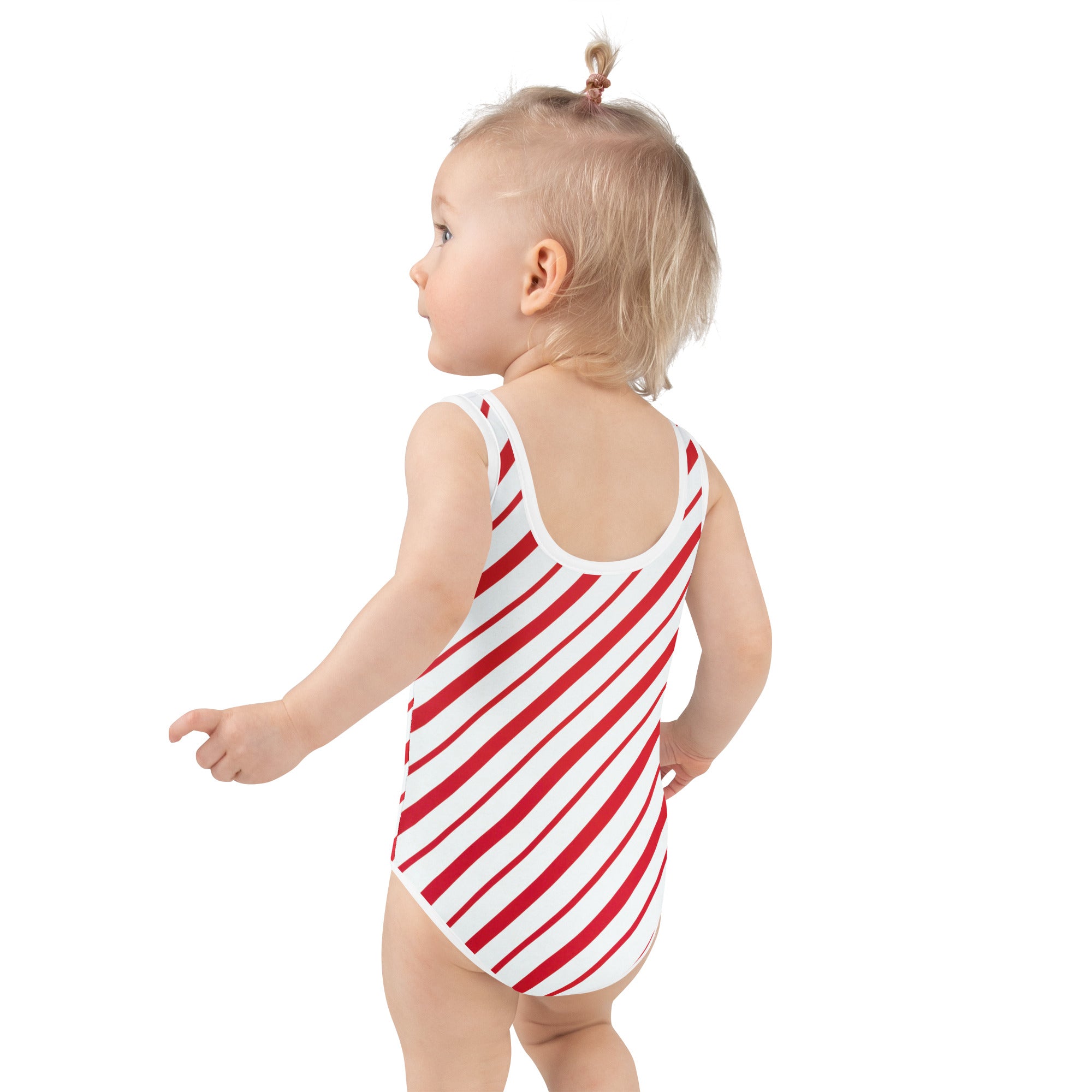 A toddler wearing a girls candy cane stripe buttery soft one-piece swimsuit with red and white stripes and UPF 50+ protection